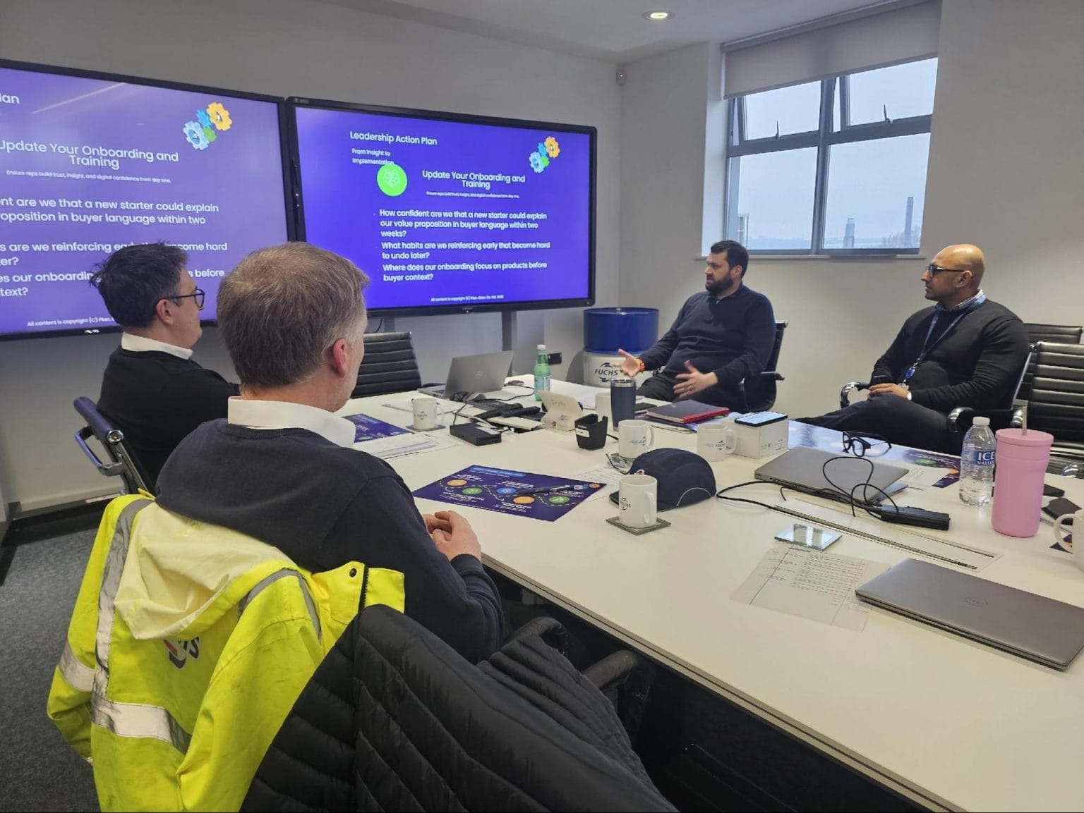 A leadership team around a boardroom table working through a leadership action plan with Plan Grow Do