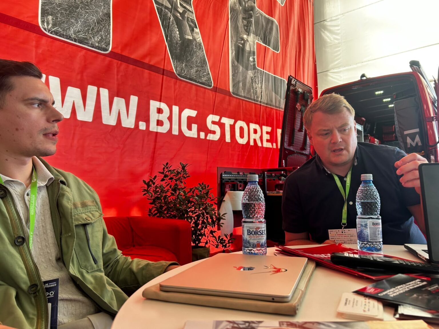 Walking a visitor through the software on a laptop at an exhibition stand